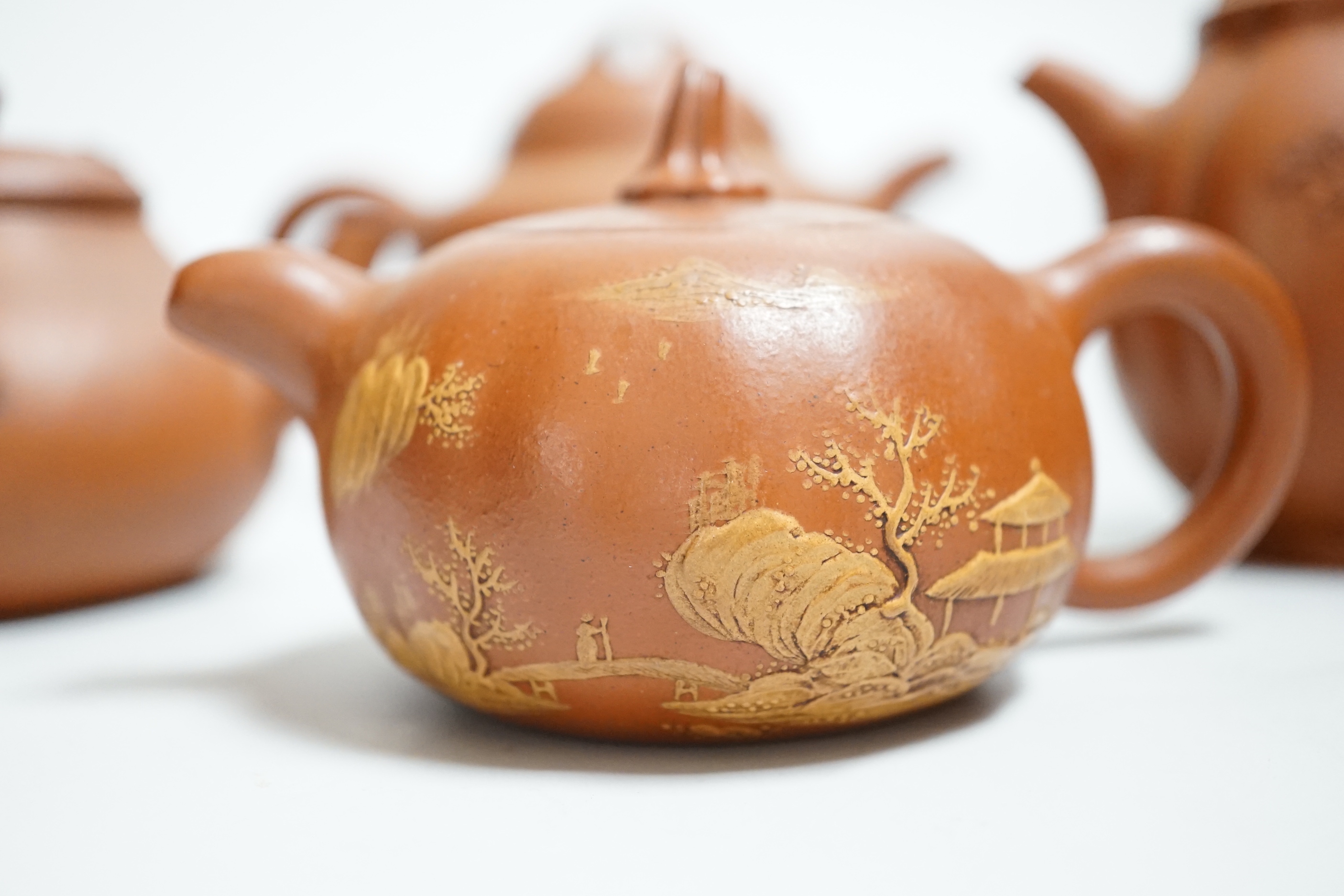 Four Chinese Yixing teapots, one slip decorated with a landscape